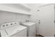 Bright laundry room with washer, dryer, and storage shelves at 25617 W St James Ave, Buckeye, AZ 85326