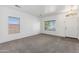 Carpeted living room with lots of natural light, neutral color palette, and a view of the front door at 25617 W St James Ave, Buckeye, AZ 85326