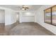 Spacious carpeted living room with neutral colors, a ceiling fan, and views into other rooms at 25617 W St James Ave, Buckeye, AZ 85326