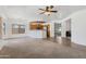 Bright living room featuring carpet and tile flooring, ceiling fan, and view into the kitchen with wood cabinets at 25617 W St James Ave, Buckeye, AZ 85326