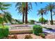 Silva Mountain community entrance featuring lush landscaping and towering palm trees against a clear blue sky at 2614 W Fawn Dr, Phoenix, AZ 85041
