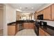 Open kitchen area with stainless steel dishwasher, black appliances, tile floor, and plenty of counter space at 2614 W Fawn Dr, Phoenix, AZ 85041