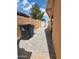 A paved side yard leads to a metal gate with a brick wall and garbage bins at 3041 E Osborn Rd, Phoenix, AZ 85016