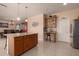 Kitchen island featuring granite countertops, seating, tile floors and ample cabinet space at 3443 W Saint Anne Ave, Phoenix, AZ 85041