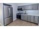 Modern kitchen with gray cabinets, stainless steel appliances, and wood-look tile flooring at 357 E Thomas Rd # A112, Phoenix, AZ 85012