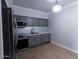 Modern kitchen with gray cabinets, stainless steel appliances, and wood-look tile flooring at 357 E Thomas Rd # A112, Phoenix, AZ 85012