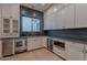 A butler's pantry features white cabinets, sink, stainless dishwasher, and wine cooler at 3950 E Augusta Ave, Queen Creek, AZ 85142