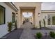 Inviting walkway and architectural stone archway to the home's entrance with lush landscaping at 3950 E Augusta Ave, Queen Creek, AZ 85142