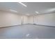Spacious garage with epoxy flooring, overhead lighting, and access doors at 3950 E Augusta Ave, Queen Creek, AZ 85142