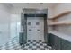 Laundry room featuring gray-green cabinetry, quartz countertops, mosaic backsplash, and checkered tile floors at 3950 E Augusta Ave, Queen Creek, AZ 85142