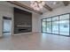 Bright open-concept living room with hardwood floors, a fireplace, beams, and floor-to-ceiling sliding glass doors at 3950 E Augusta Ave, Queen Creek, AZ 85142