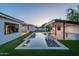 Backyard with a modern pool, spa, outdoor kitchen, and manicured landscaping, perfect for entertaining at 3950 E Augusta Ave, Queen Creek, AZ 85142