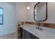 Powder room featuring a wood framed mirror, a globe pendant light, and a dark wood sink cabinet at 3950 E Augusta Ave, Queen Creek, AZ 85142