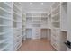 Bright walk-in closet featuring custom white shelving, drawers, hanging rods, and matte black hardware at 3950 E Augusta Ave, Queen Creek, AZ 85142