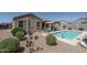 A well-manicured backyard features a pool, decorative plants, and a covered patio at 4001 N 300Th Ln, Buckeye, AZ 85396