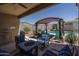 Backyard patio with shaded seating area and views of the pool and landscaping at 4001 N 300Th Ln, Buckeye, AZ 85396