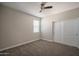 Cozy bedroom with a ceiling fan, neutral walls, carpet flooring, and closet with sliding doors at 4001 N 300Th Ln, Buckeye, AZ 85396