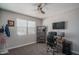 Cozy bedroom features a ceiling fan, window with blinds, and home office setup at 4001 N 300Th Ln, Buckeye, AZ 85396