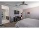 Relaxing main bedroom featuring a ceiling fan, TV, and an en-suite bathroom at 4001 N 300Th Ln, Buckeye, AZ 85396