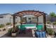 Backyard pool with relaxing lounge chairs under a pergola with a shaded area at 4001 N 300Th Ln, Buckeye, AZ 85396