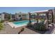 Backyard pool area featuring a pergola with lounge chairs and desert landscaping at 4001 N 300Th Ln, Buckeye, AZ 85396