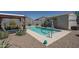 Backyard pool area featuring an outdoor seating area, lush greenery, and gravel groundcover at 4001 N 300Th Ln, Buckeye, AZ 85396