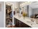 Primary bathroom with double sink vanity, large mirror, and a view of the walk-in closet, providing ample space at 4118 W Fallen Leaf Ln, Glendale, AZ 85310