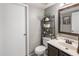 Well-lit bathroom featuring dark wood vanity, silver walls, decor, and decorative wall shelving over the toilet at 4118 W Fallen Leaf Ln, Glendale, AZ 85310