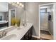 Primary bathroom with a dual sink vanity, modern finishes, and a glass-enclosed shower, all with great natural light at 4118 W Fallen Leaf Ln, Glendale, AZ 85310