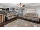 Open-concept living room featuring hardwood floors, neutral paint, and comfortable seating, illuminated by modern ceiling fan with light at 4118 W Fallen Leaf Ln, Glendale, AZ 85310