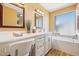 Vanity and bathtub in primary bathroom with large mirrors and natural light at 4420 E Amberwood Dr, Phoenix, AZ 85048