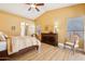 Bright bedroom features wood floors, ceiling fan, vaulted ceiling, and a dark wood dresser at 4420 E Amberwood Dr, Phoenix, AZ 85048