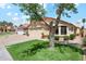 Well-maintained home featuring a lush green lawn, mature landscaping, a two-car garage, and a charming exterior at 4420 E Amberwood Dr, Phoenix, AZ 85048