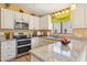 Bright kitchen with stainless steel appliances, granite countertops, and ample cabinet space at 4420 E Amberwood Dr, Phoenix, AZ 85048