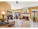 Warm living room featuring a brick fireplace, wood floors, and large windows at 4420 E Amberwood Dr, Phoenix, AZ 85048