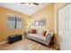 Comfortable living room is furnished with a tufted sofa, lamps, and ottomans at 4420 E Amberwood Dr, Phoenix, AZ 85048