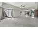 Large living room with carpet and tile flooring, ceiling fan, and sliding glass doors to courtyard at 4525 N 66Th St # 85, Scottsdale, AZ 85251