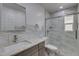 Bathroom featuring a granite vanity, walk-in shower with new glass door, and tiled walls at 542 E Flynn Ln, Phoenix, AZ 85012
