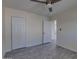 Spacious bedroom featuring wood-look tile flooring, a ceiling fan, and double door closet at 542 E Flynn Ln, Phoenix, AZ 85012