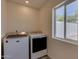 Bright laundry room equipped with new washer, dryer, and a window providing natural light at 542 E Flynn Ln, Phoenix, AZ 85012