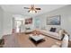 Bright living room featuring neutral walls, plush seating, ceiling fan, and seamless flow into the kitchen space at 6330 W Constance Way, Laveen, AZ 85339