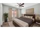 Bedroom featuring a ceiling fan, ensuite bathroom, and two large windows with natural light at 6330 W Constance Way, Laveen, AZ 85339