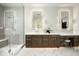 Elegant bathroom with marble floors, dual illuminated mirrors, and a glass shower showcasing modern design at 7001 E Joan De Arc Ave, Scottsdale, AZ 85254