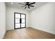 Empty bedroom with an exterior glass door, light-colored wood floors, and a modern ceiling fan at 7001 E Joan De Arc Ave, Scottsdale, AZ 85254