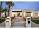 Modern home exterior featuring a desert landscape with palm trees and a walkway leading to the entrance at 7001 E Joan De Arc Ave, Scottsdale, AZ 85254