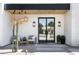 Charming front porch with modern lighting, a black-framed glass door, and stylish outdoor seating at 7001 E Joan De Arc Ave, Scottsdale, AZ 85254