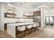 Contemporary kitchen with a large island, bar seating, stainless steel appliances, and stylish pendant lights at 7001 E Joan De Arc Ave, Scottsdale, AZ 85254
