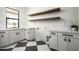 Bright laundry room features checkerboard floors, ample cabinets with dark hardware, plus marble countertops and backsplashes at 7001 E Joan De Arc Ave, Scottsdale, AZ 85254