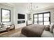 Serene main bedroom showcases a fireplace, sliding glass doors and sleek chandelier for a luxurious escape at 7001 E Joan De Arc Ave, Scottsdale, AZ 85254