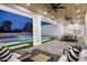 Beautiful covered patio with outdoor seating, a full outdoor kitchen, and a view of the sparkling pool at 7001 E Joan De Arc Ave, Scottsdale, AZ 85254